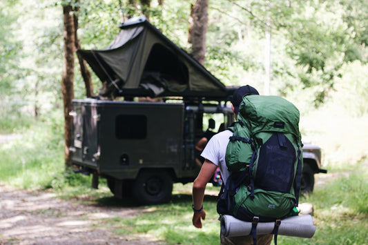 a man with a backpack walking towards a truck
